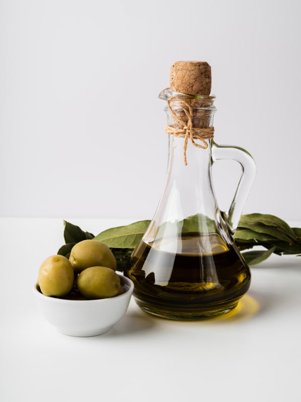 Oil cruet with some olives and a few laurel leaves