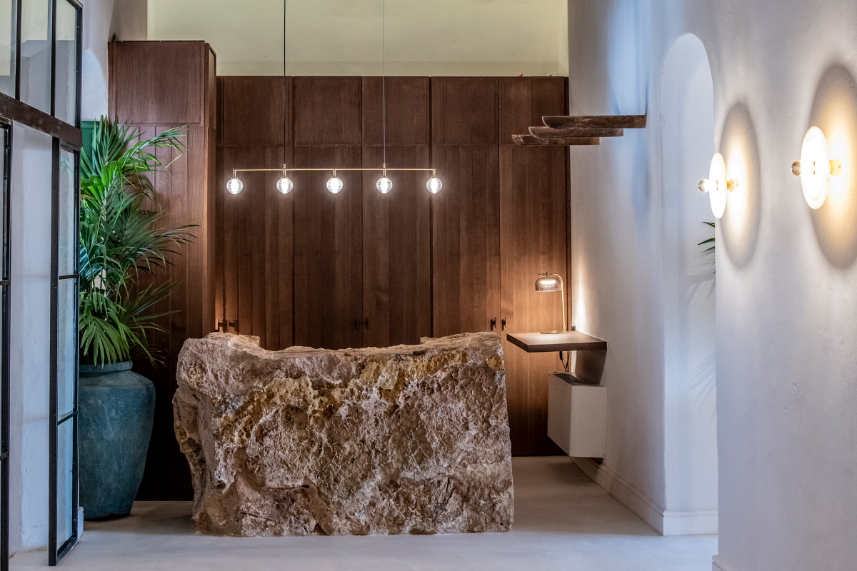Mostrador de recepción labrado en piedra y con iluminación de diseño