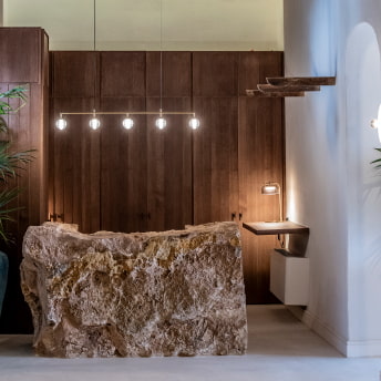 Mostrador de recepción labrado en piedra y con iluminación de diseño