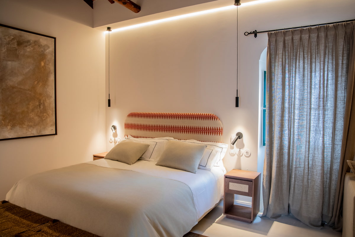 Cama en Habitacion Doble, con cabecero tapizado en colores crudo y rojizos