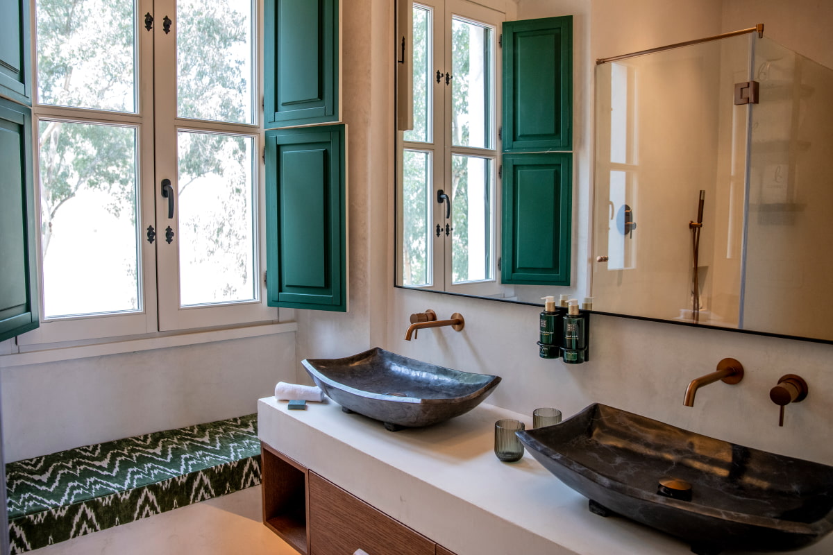 Cuarto de baño con luz natural y lavabo doble sobre encimera de diseño
