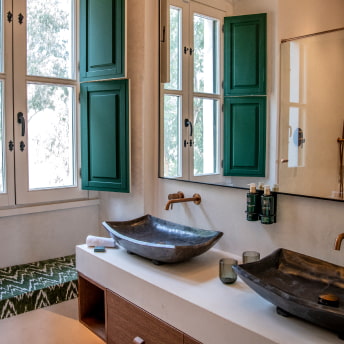Cuarto de baño con luz natural y lavabo doble sobre encimera de diseño