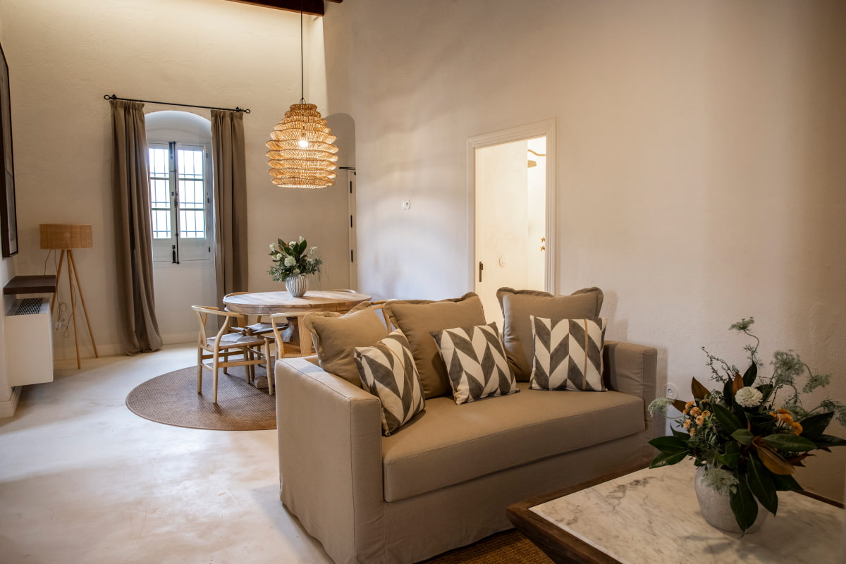Amplia zona con sofá, mesas, sillas y decoración floral
