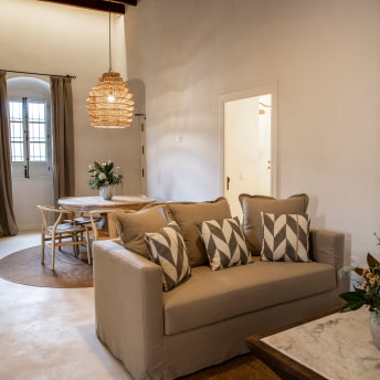 Amplia zona con sofá, mesas, sillas y decoración floral