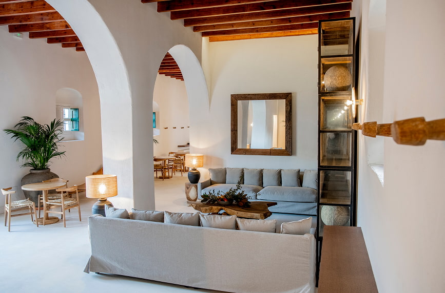 Zona descanso hotel Estania equipada con dos sofas de color beige y decoración con muebles de madera