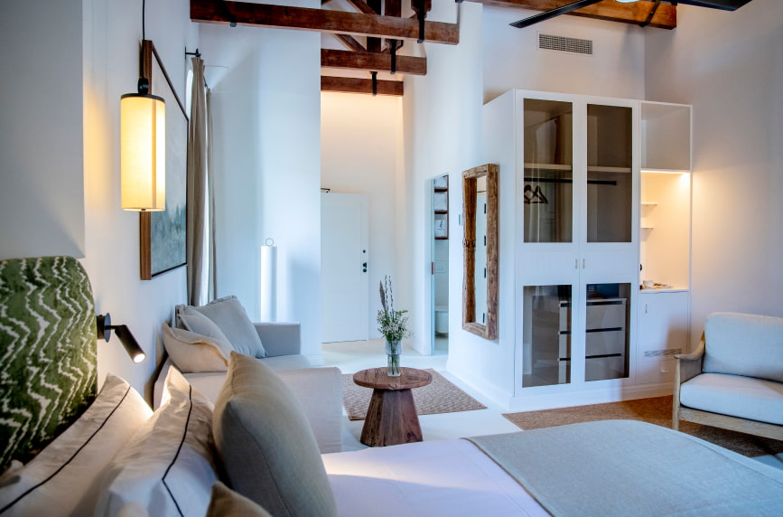 Habitación Hotel Corbella 1 Estancia de colores blanco equipada con muebles con acabado de madera