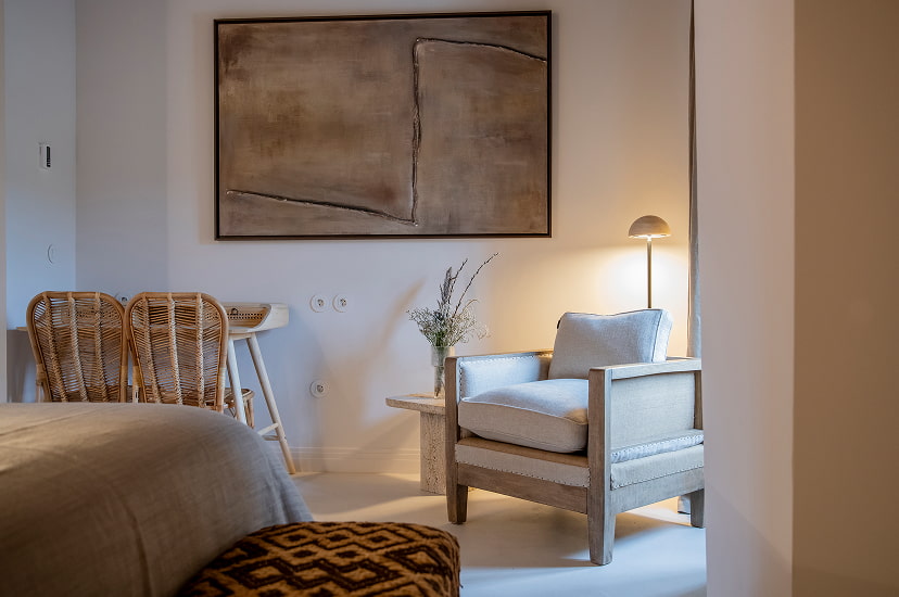 Detail of one of the hotel rooms, with wicker armchair and desk.