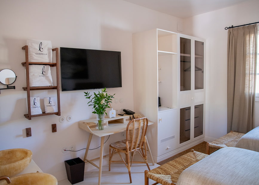 Desk and wardrobe area, with TV hanging on the wall