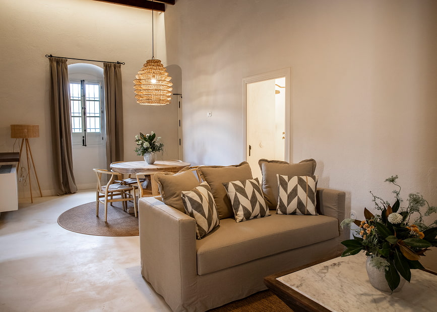 Area equipped with sofa, tables, chairs and floral decoration.