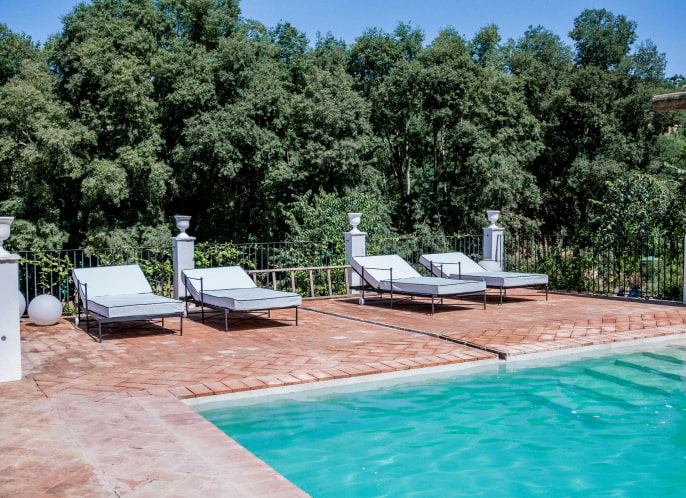 Outdoor swimming pool Swimming pool surrounded by nature and equipped with sunbeds